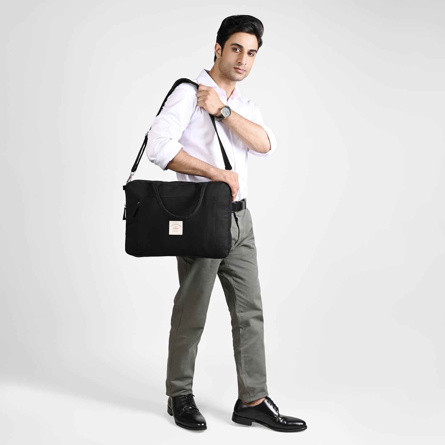 Black Sustainable Laptop Bag made from Canvas fabric male model image with side sling handle image
